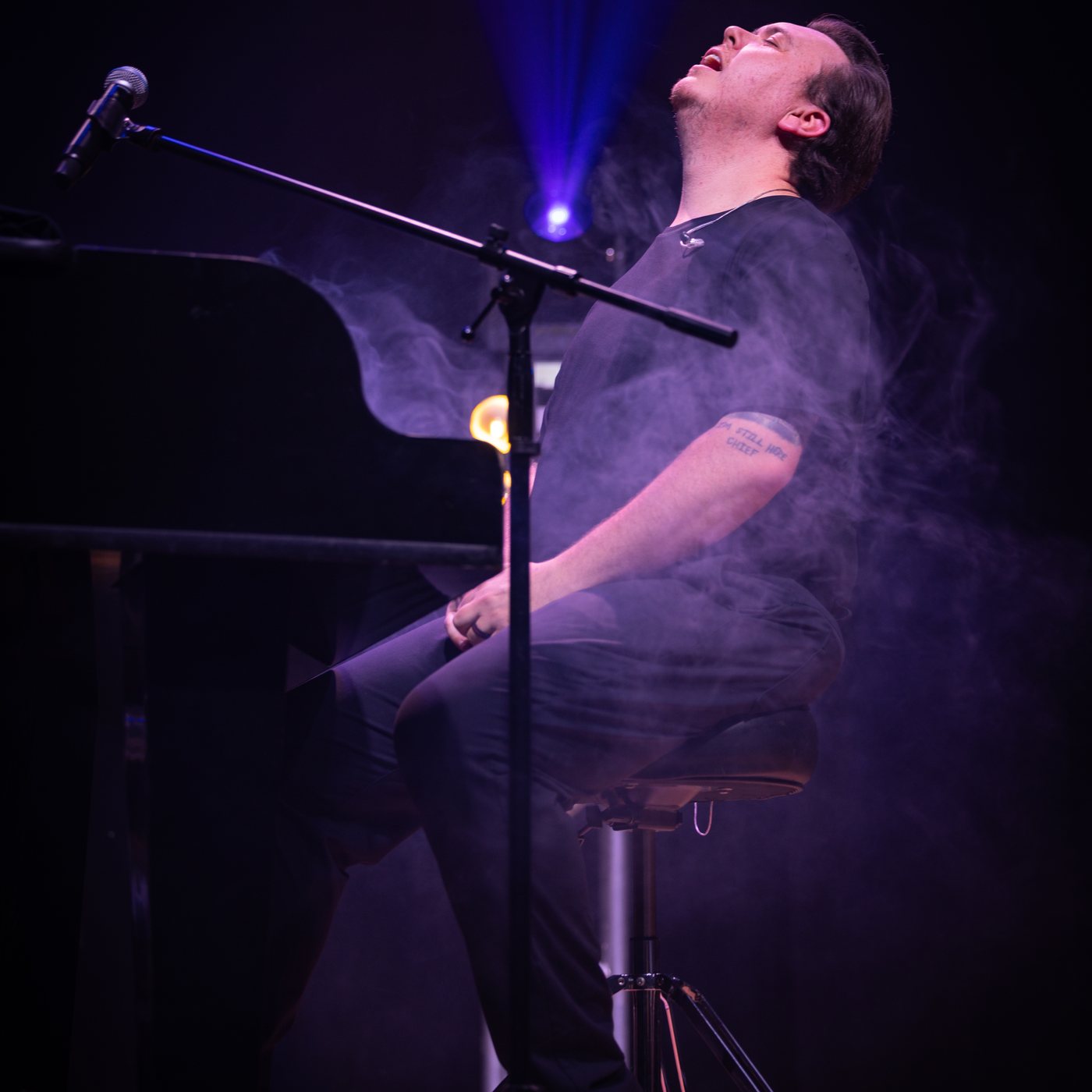 Nick Davies at the piano under a spotlight